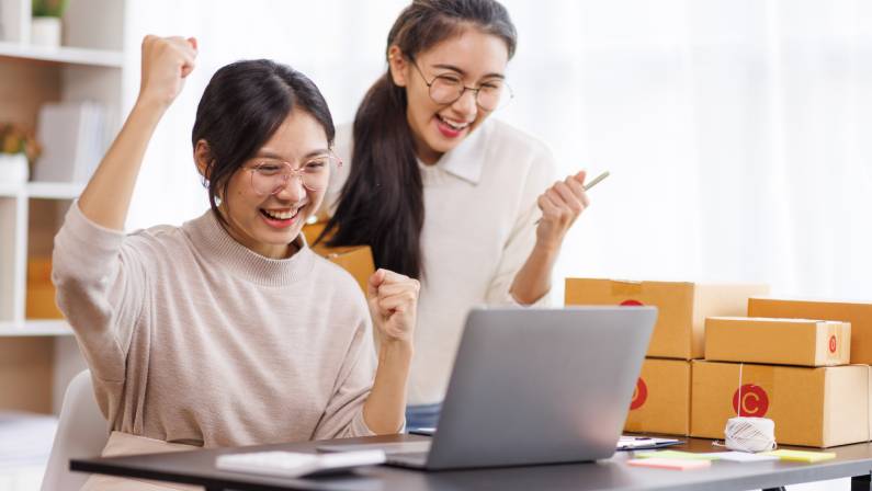 Two Young Asian women are happy and excited after a successful B2B digital marketing campaign