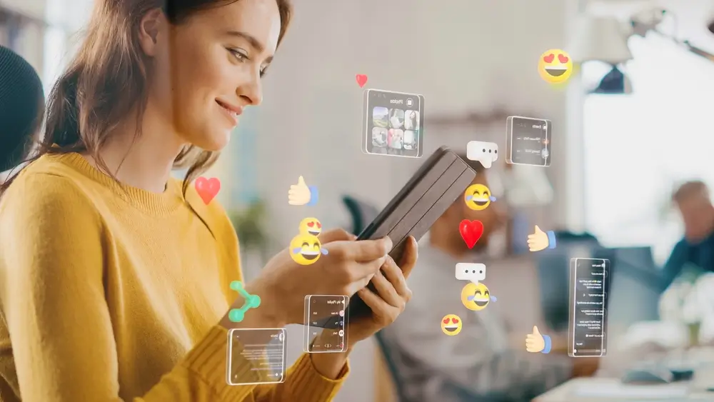 Happy Young Woman Uses Digital Tablet Computer in the Office, Social Media Posts, Smiley Faces, e-Commerce Online Shopping Digital Icons Flying Around the Device