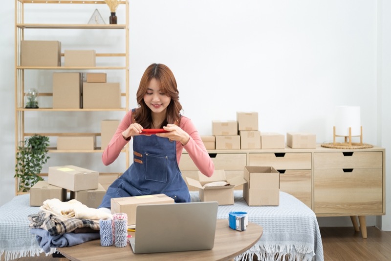 Happy female selling products online. Delivery service concept.