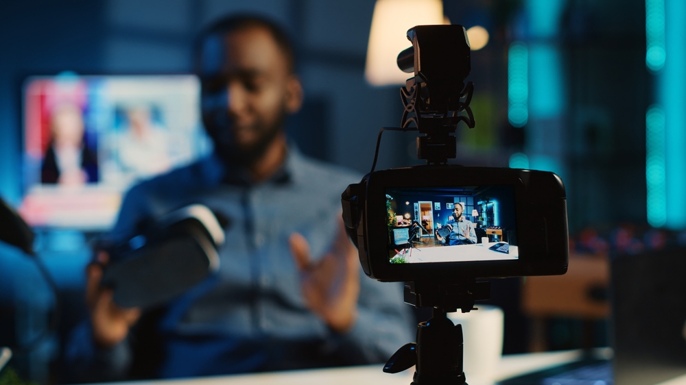 African american influencer showing virtual reality goggles to subscribers