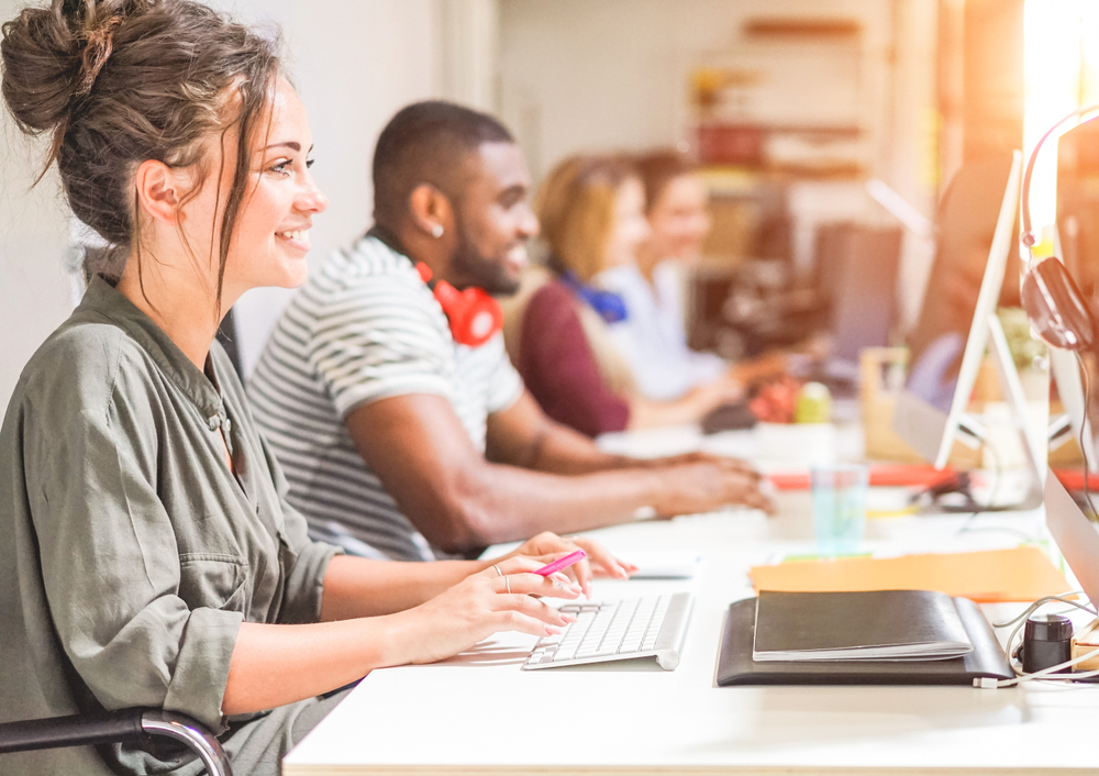 Young trendy teamwork using computer in creative office