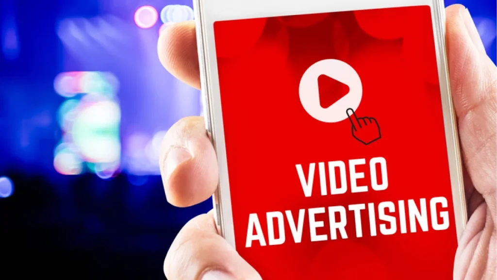 Close up hand holding mobile phone with Video advertising word on screen with blur concert bokeh light background,Digital media marketing concept