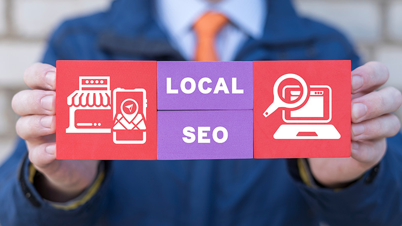 Man holding colorful blocks with icons and inscription: LOCAL SEO. Local search marketing e-commerce. Concept of local seo strategy, local search optimization.