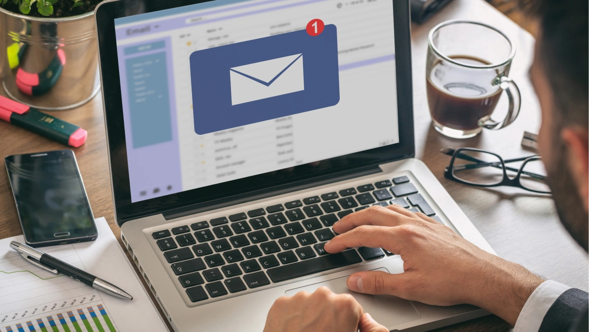Email notification concept, man working with a computer laptop, one new inbox e mail message on the screen, business office desk background