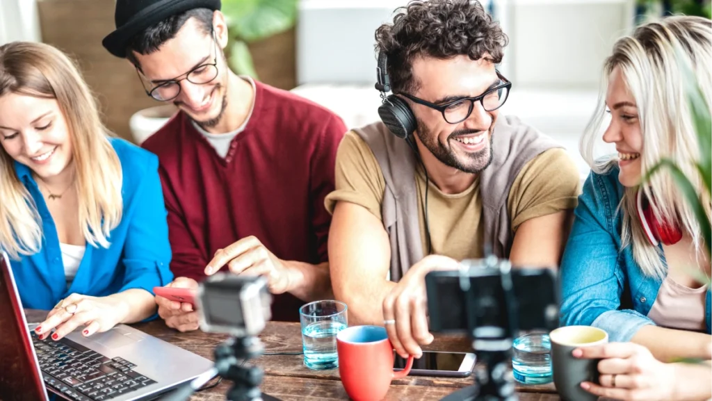 Young happy students sharing content on streaming platform with digital web cam - Modern life style concept with millenial guys and girls having fun vlogging live feeds on social media - Vivid filter