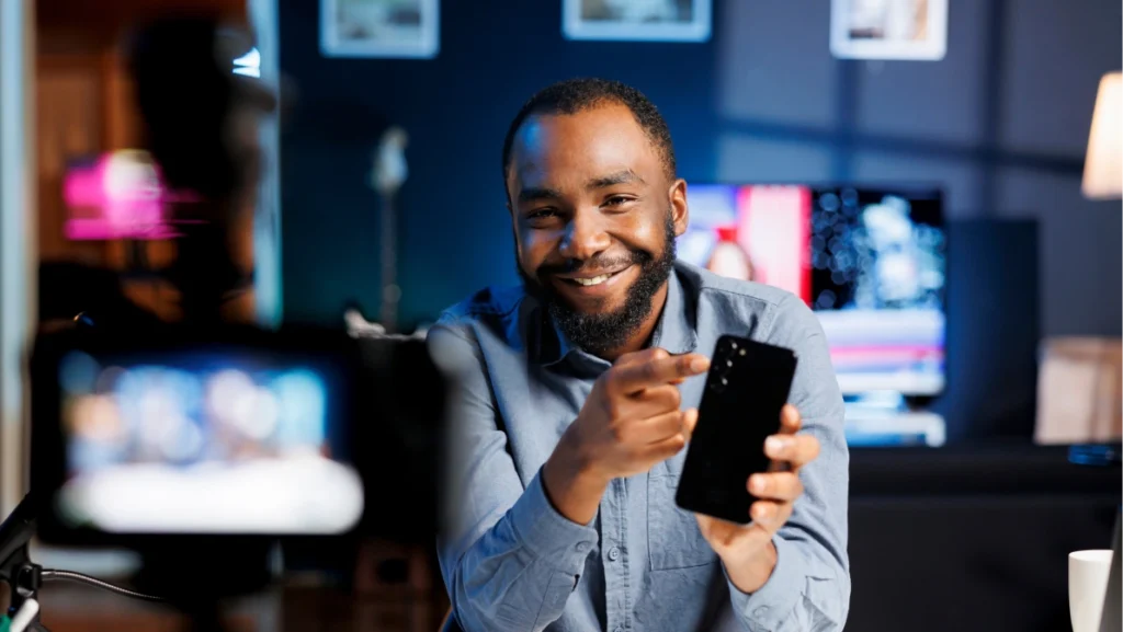 Internet show host being sponsored by partnering brand to do cellphone unboxing content. Technology enthusiast does influencer marketing, doing mobile phone product commercial