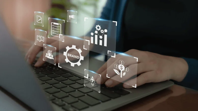 Person typing on laptop with digital icons of brand strategy and growth, symbolizing Visual vs Verbal Branding in marketing.