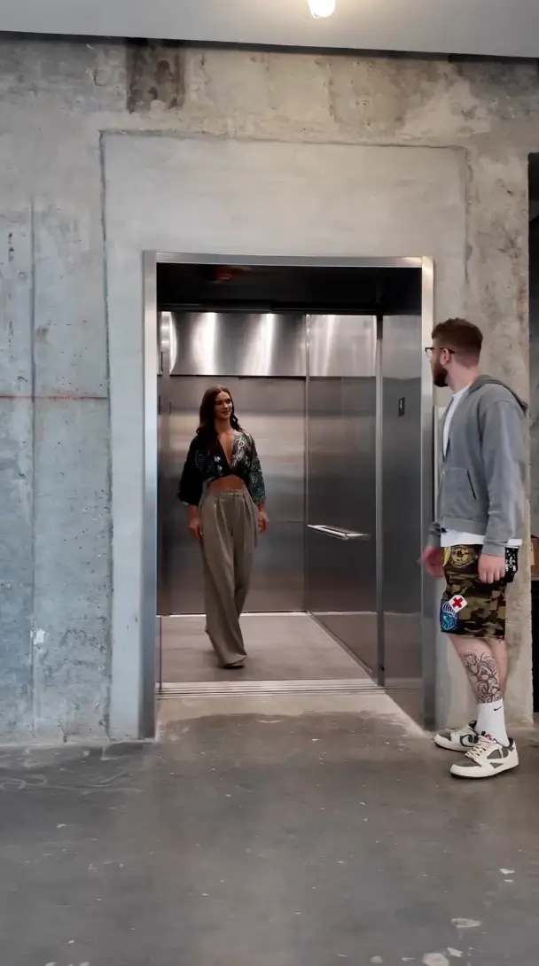 woman in elevator and man standing outside waiting