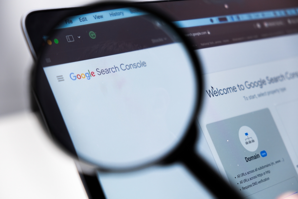 Google Search Console logo enlarged through a magnifying glass on a laptop screen