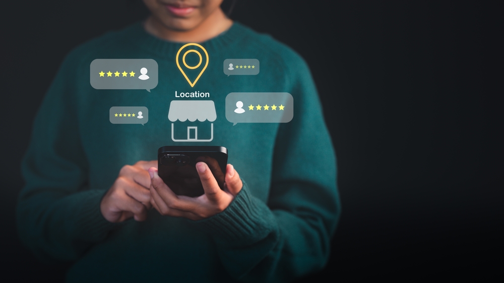 Customer using a smartphone to check local business reviews with location and star feedback icons