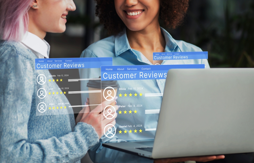Two women discussing customer reviews on laptop screen representing digital reputation marketing