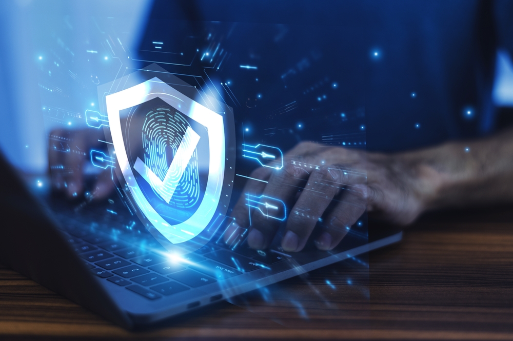 Man working on a laptop with advanced cyber security shield, ensuring protection of sensitive data
