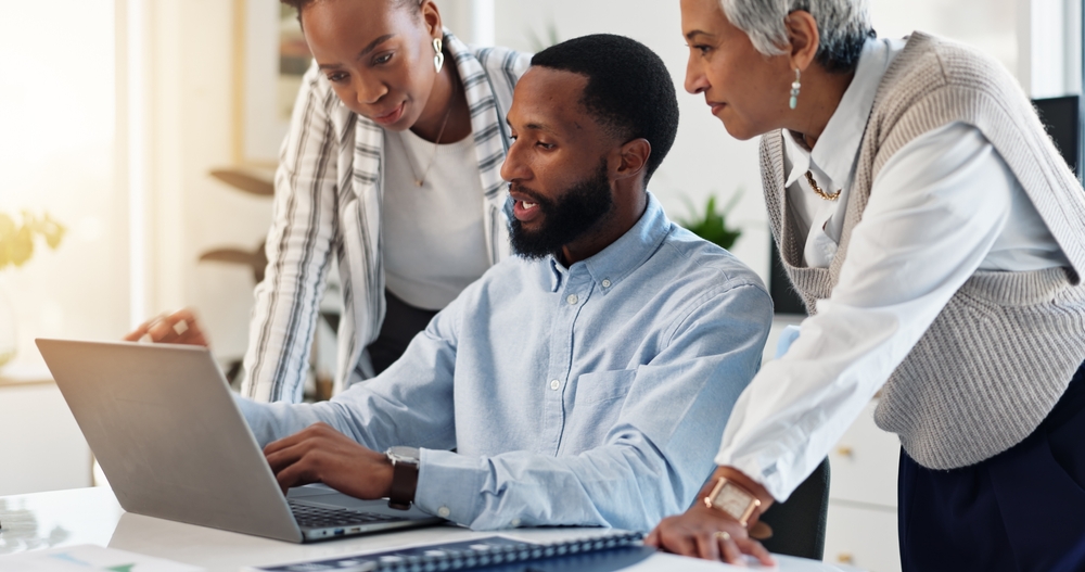 Collaboration, computer and conversation with employee group in workplace