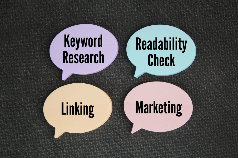 paper conversation bubbles with the words keyword research, readability check, linking, and marketing.