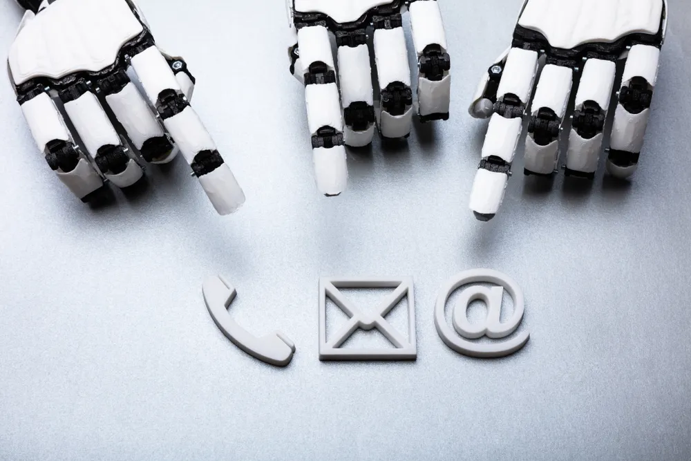 Close-up Of A Robotic Hand Pointing At Various Contact Icons On Gray Background