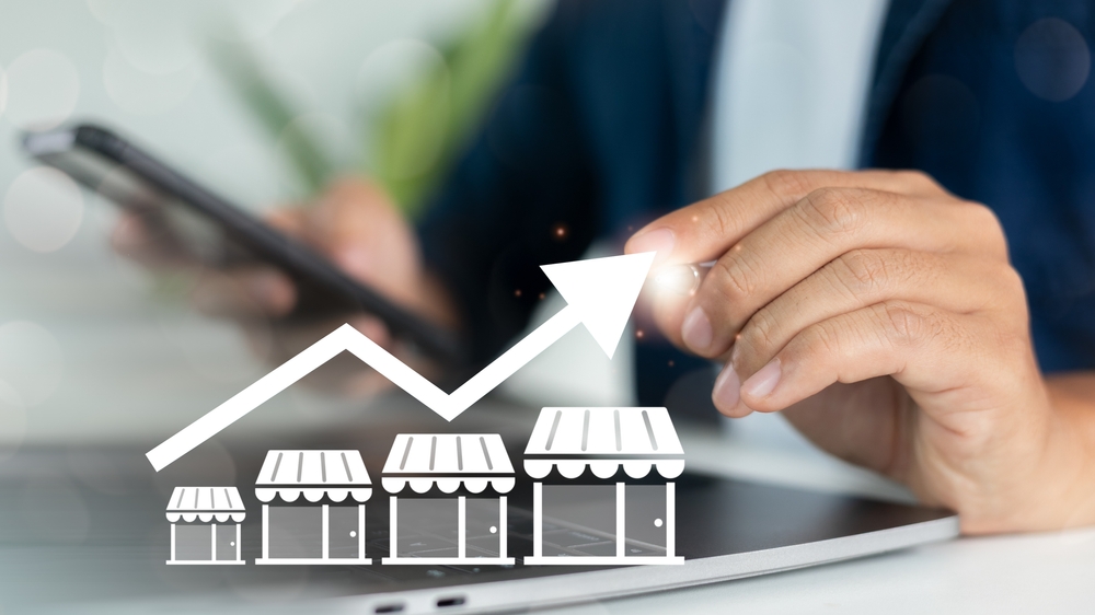 Close-up of a hand using a smartphone with increasing store graph icons