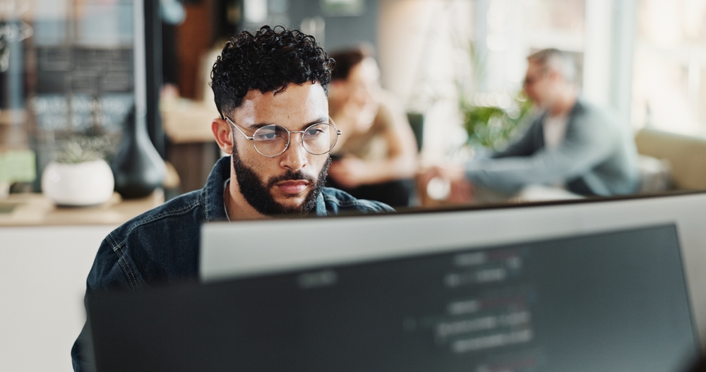 Coding, computer and web development with man in creative workplace