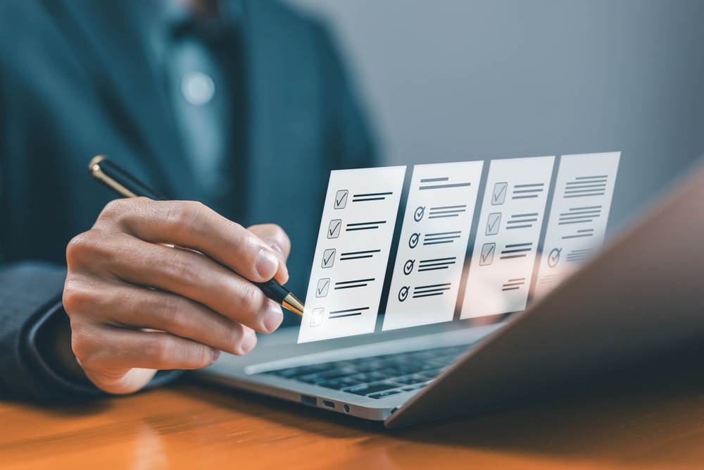 task audit in a list of documents, tick the checkmark in the survey item on a laptop