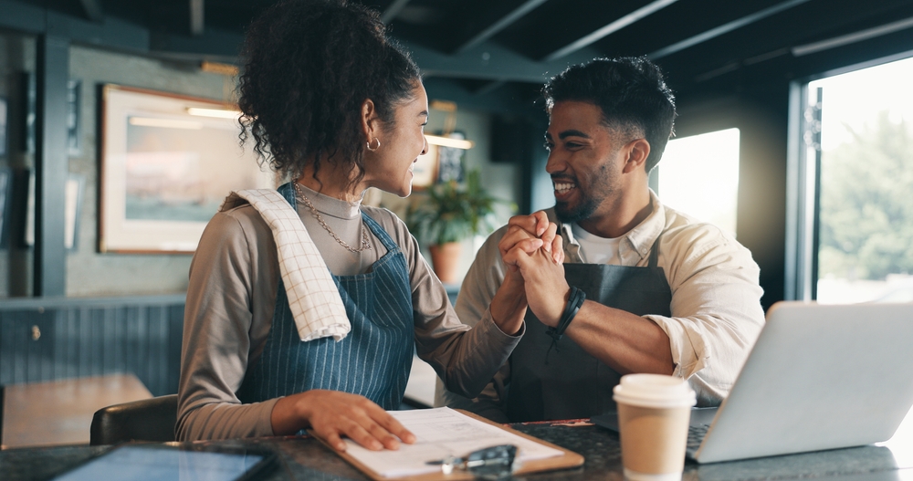 Business owners, high five and people in restaurant, laptop
