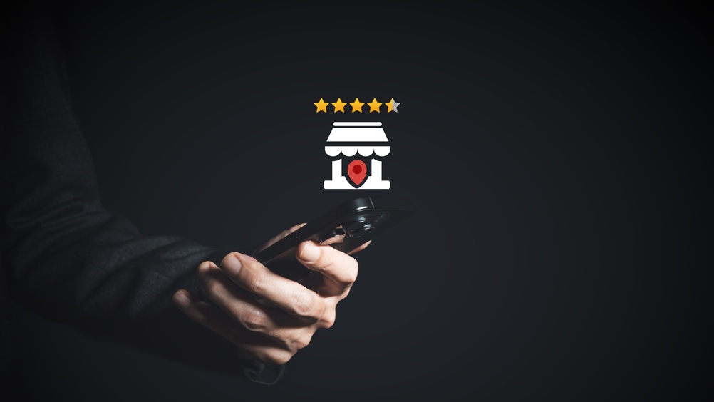 Business owner checking restaurant star rating and customer reviews on smartphone