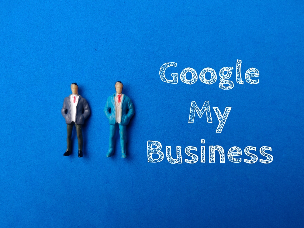 Miniature people with text Google My Business on blue background. Business concept.