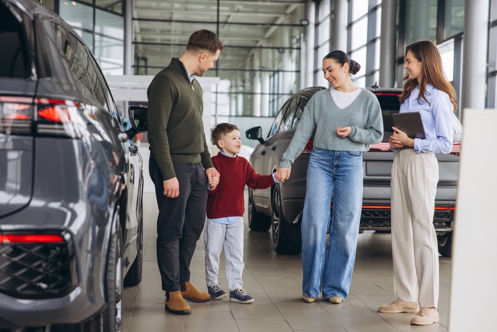 Family with child visiting a car showroom for selecting a new vehicle.