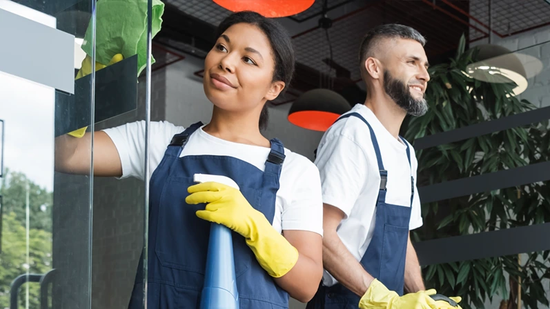 interracial women washing glass entrance in office near man with floor scrubber machine, banner