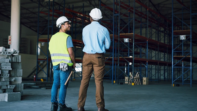 Construction, happy or people at warehouse with inspection, feedback or safety check in site maintenance. Smile, contractor or supervisor with review, compliance or protocol in factory evaluation.