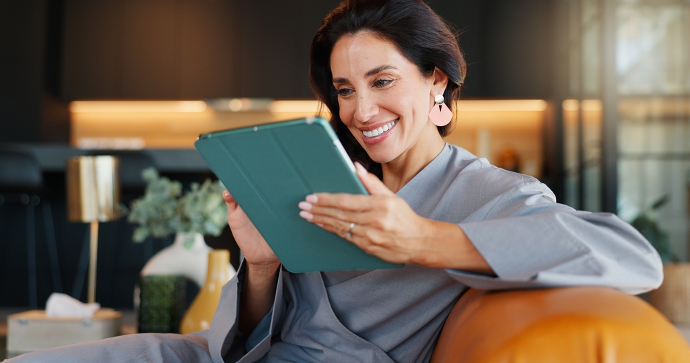 Online booking, smile and tablet with woman in spa for appointment or schedule