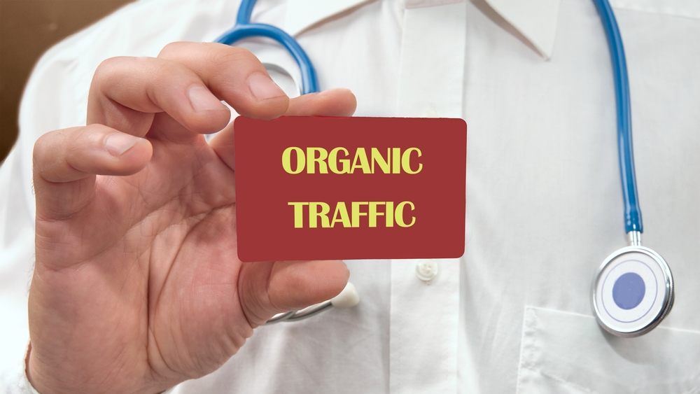 The word ORGANIC TRAFFIC written on the red card in the man's hand