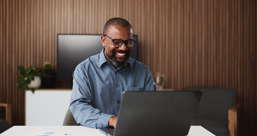 Laptop, lawyer and happy black man in office for research, proposal and success for case study.