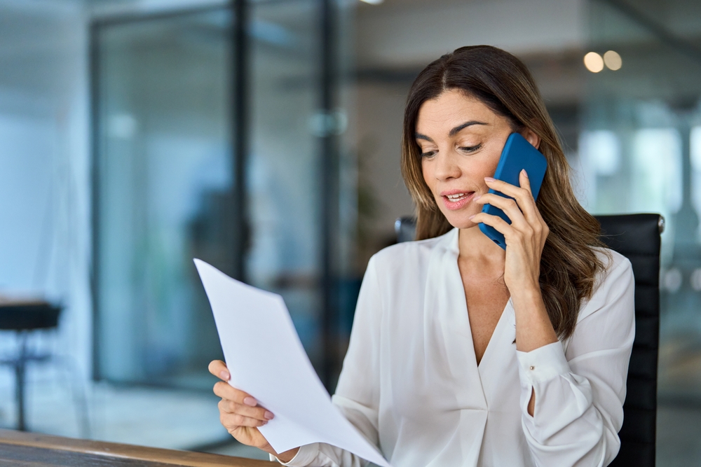 Busy middle aged professional business woman executive making call having conversation at work. 