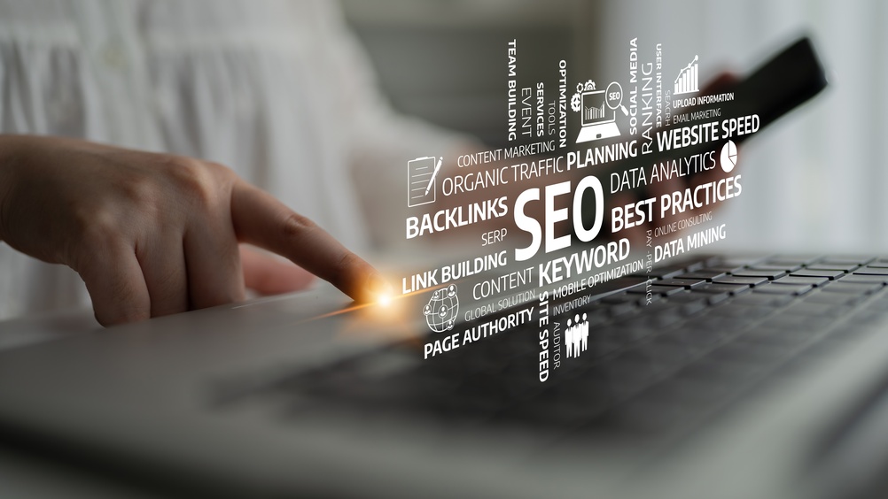 A business professional interacts with a laptop while analyzing SEO strategies.