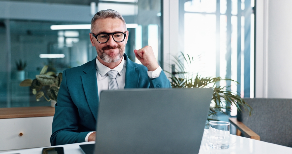 Businessman celebrating with fist pump for winning and settlement for corporate case
