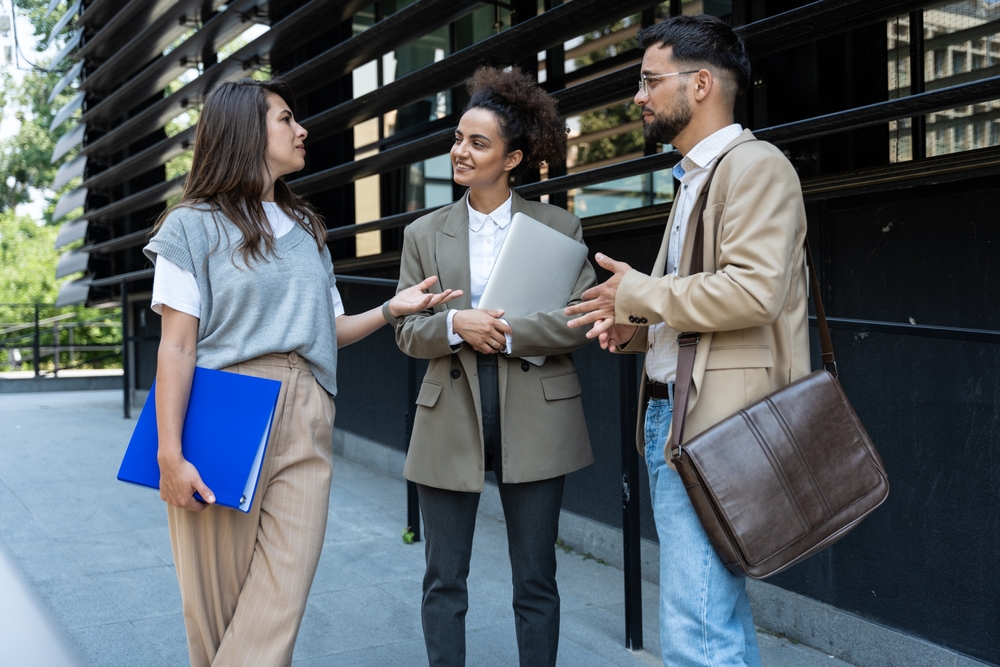 Young business professionals networking outside an office building.
