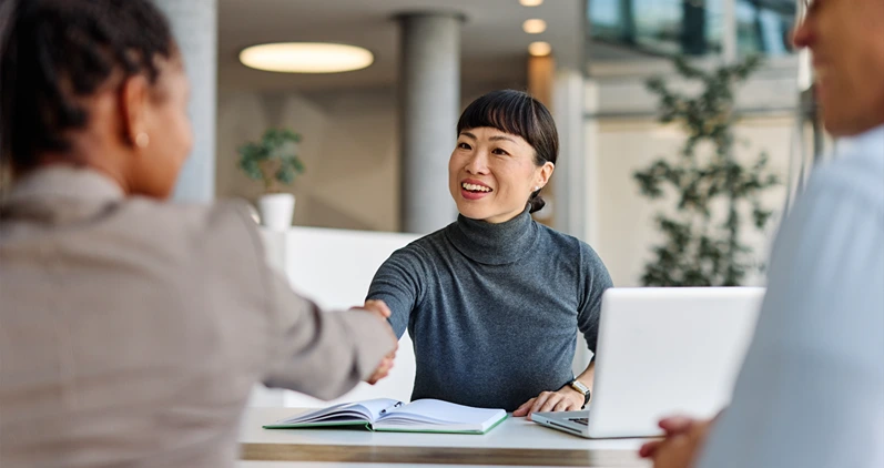 Business people having a meeting shaking hands introducing each other or making a deal agreement