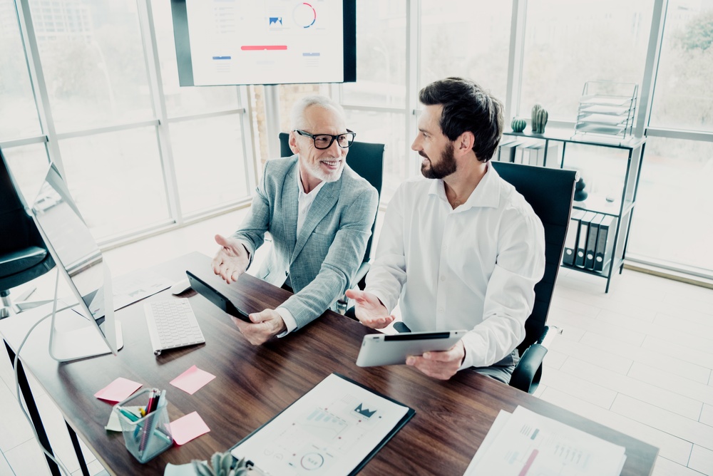 Two professionals share ideas during a business meeting in a bright office.