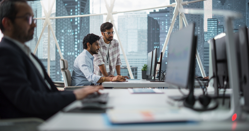 Two Indian Colleagues Having a Conversation While Busy Working on a Business Project. 