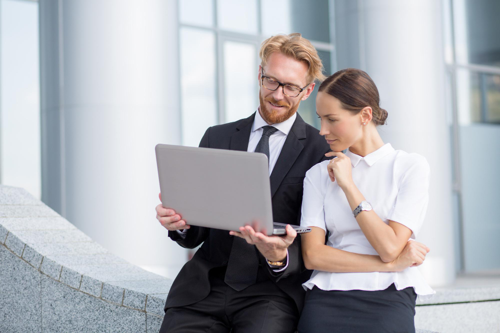 Red-haired man in glasses keeping laptop