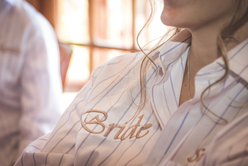 Bride wearing casual shirt with the word bride embroidered closeup