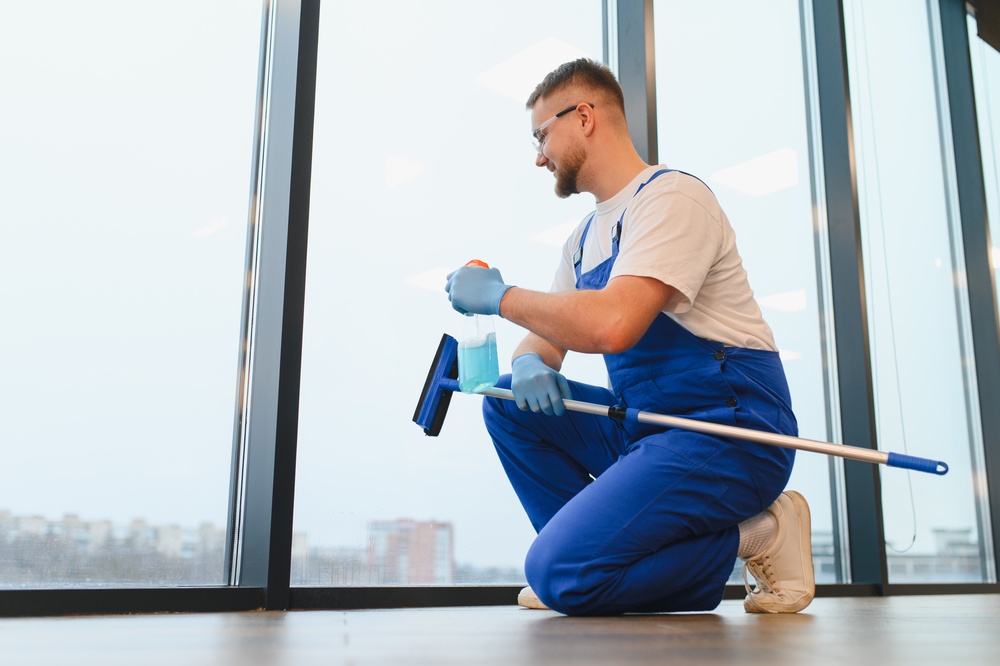 Professional cleaner with blue uniform and safety glasses