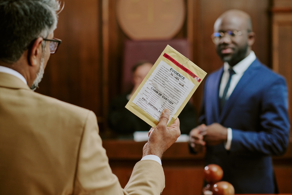 Middle aged Caucasian man holding evidence bag while standing in courtroom