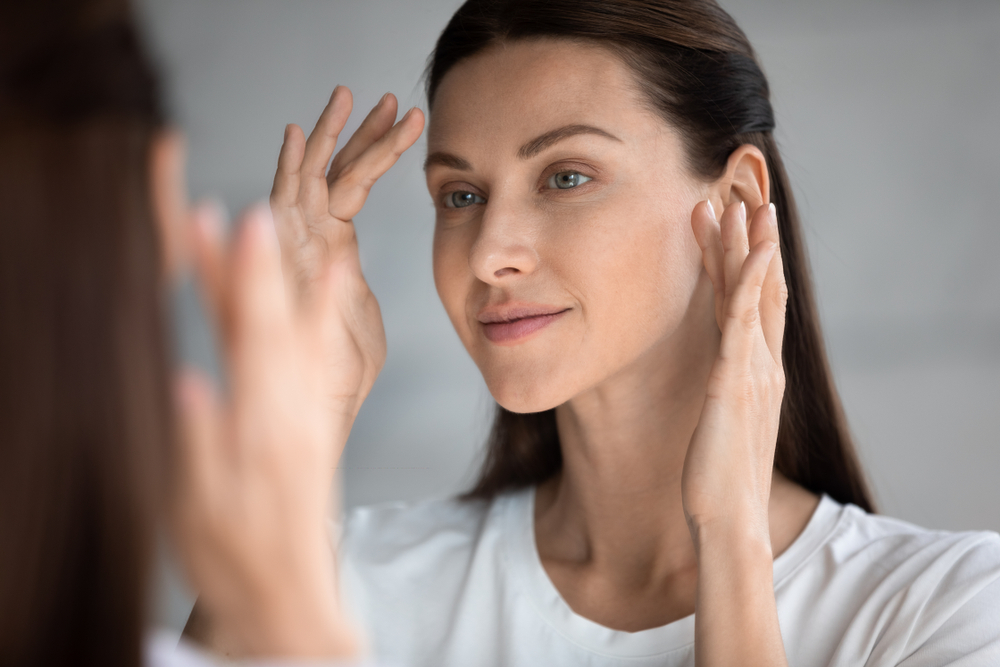 Close up beautiful woman looking in mirror in bathroom