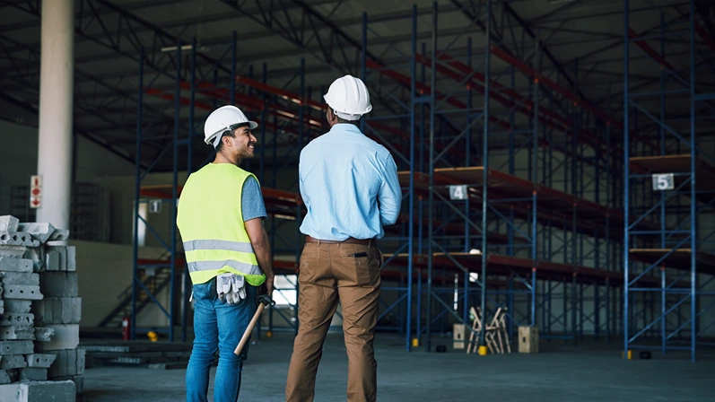 Construction, happy or people at warehouse with inspection, feedback or safety check in site maintenance. Smile, contractor or supervisor with review, compliance or protocol in factory evaluation.