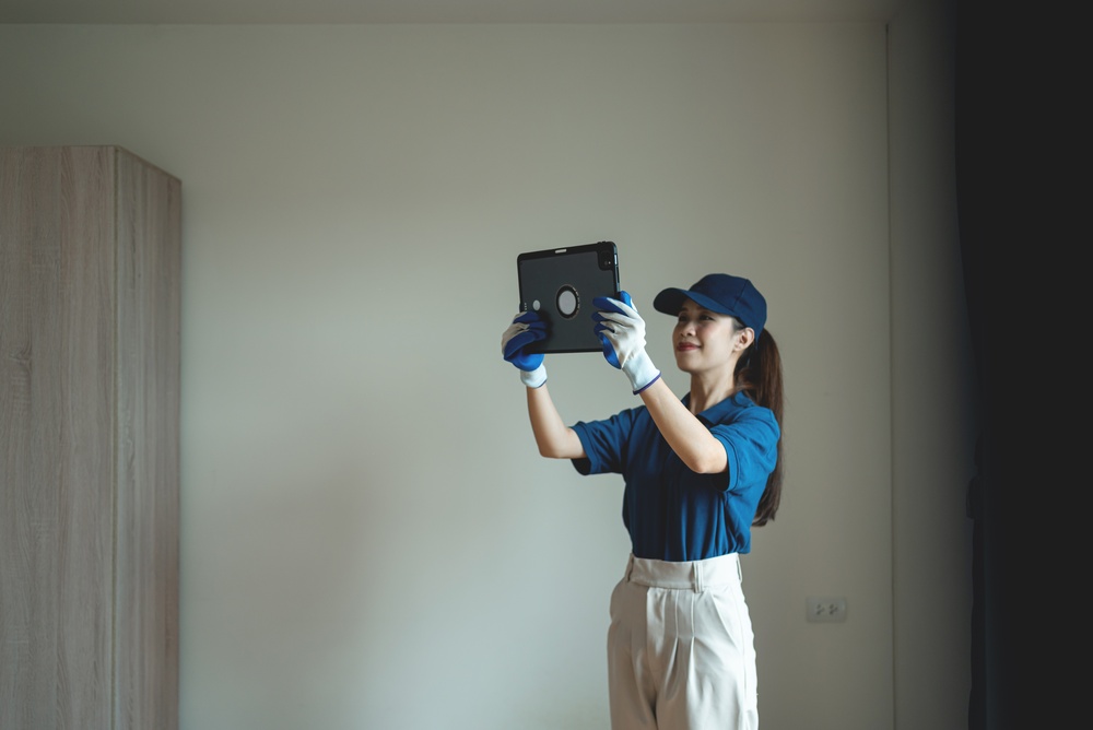 A professional housekeeper uses a digital tablet to review cleaning tasks and manage housekeeping