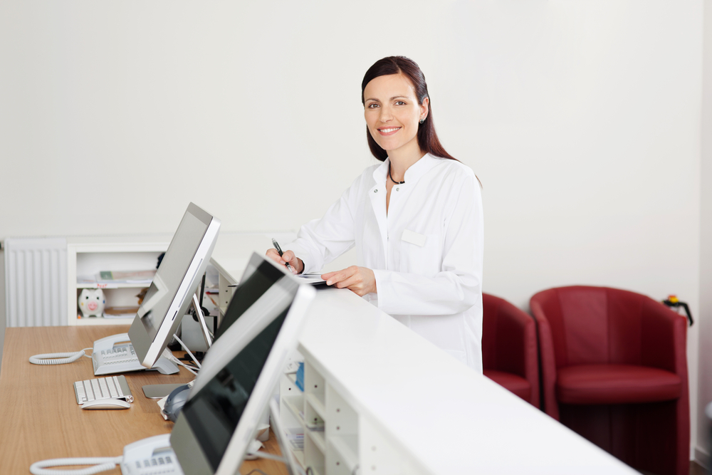 Smiling female doctor standing at the reception desk