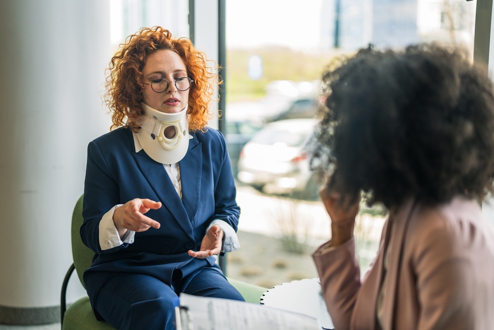 Woman with a neck brace sitting in a modern office