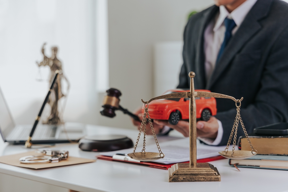 Judge male hand with car and documents and hammer