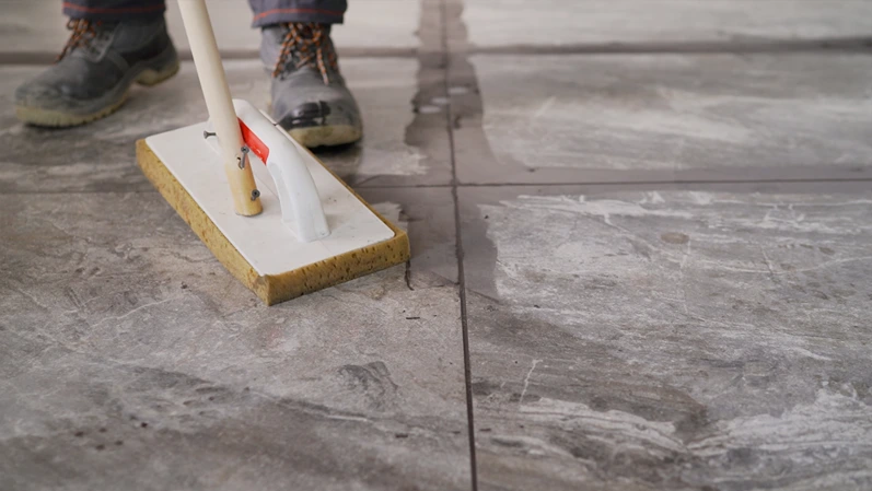 Close up of facility maintenance worker using professional floor cleaning machine.