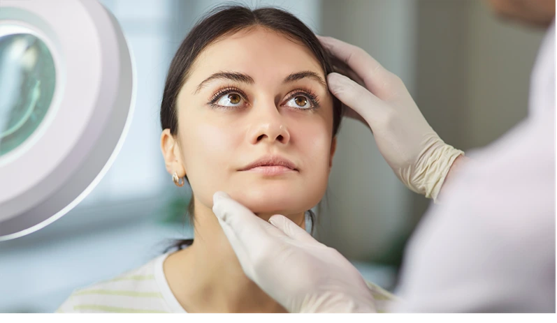 Surgeon touching woman face consulting before rhinoplasty operation. Beautician or cosmetologist examining skin condition to a young girl client. Plastic surgery and beauty concept.